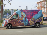 902059 Afbeelding van een geheel met graffiti bespoten transportbus, geparkeerd op de Croeselaan te Utrecht.